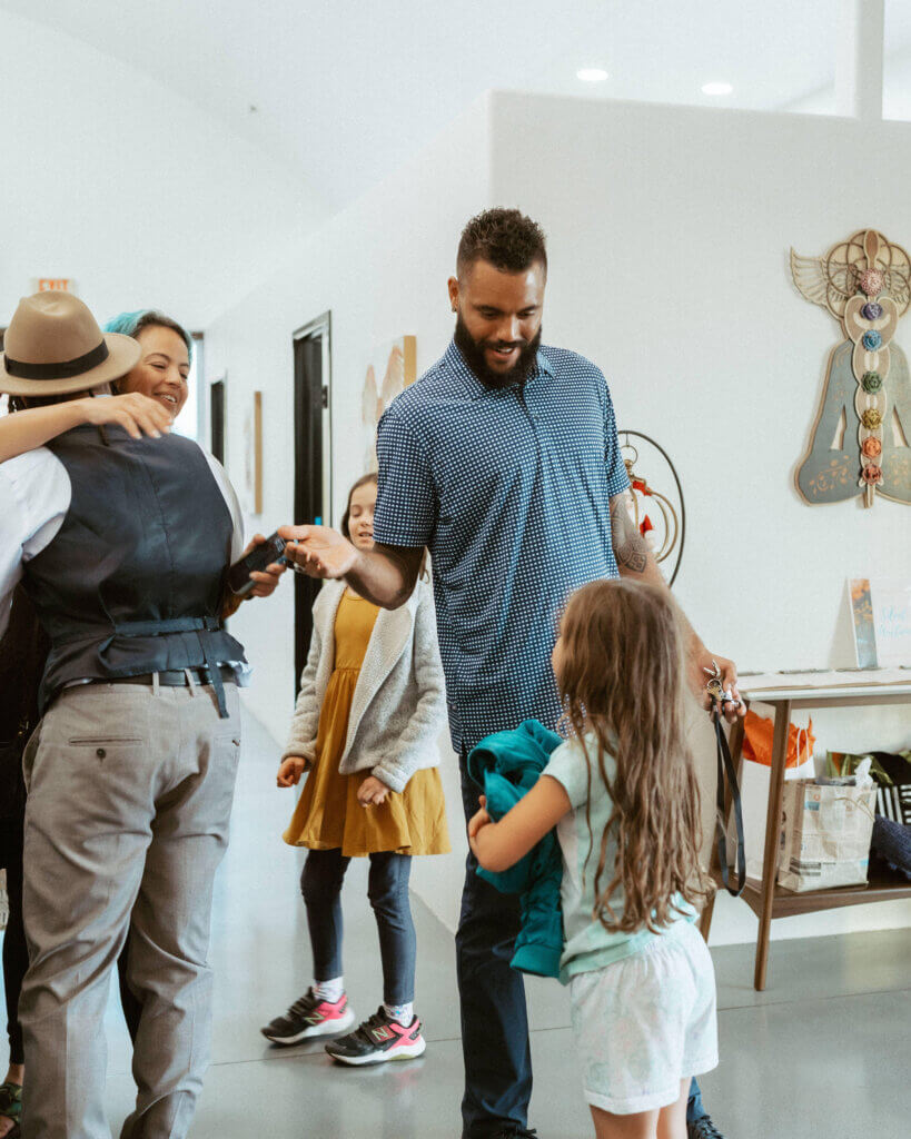 Dr. Brett and other chiropractic caregivers talking to children and hugging patients at their chiropractic adjustment clinic